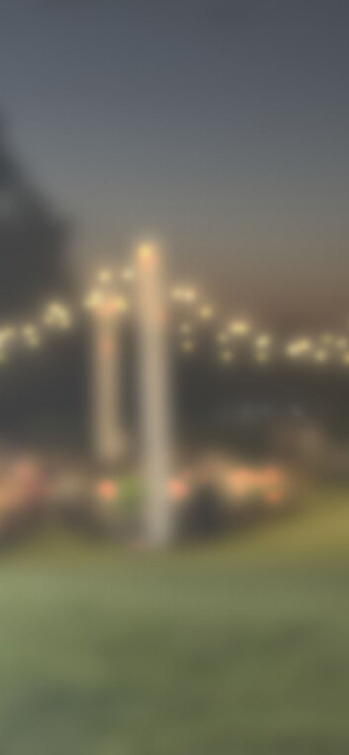 The lawn at night, every table full, softly blurred